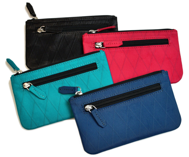 Four small quilted zipper pouches in black, red, turquoise, and blue, each with a front zipper pocket and a main zipper compartment, arranged overlapping each other.