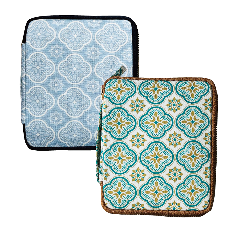 Discover the Piper Trading Co. Kyoku Haku Begonia Flowers 10 Pen Case—two patterned fabric storage pouches, perfect for use as a handmade pen case or fountain pen case. One features a blue and white geometric floral design with black trim, and the other showcases a teal, yellow, and white pattern with brown trim—both designed to stand upright for easy access and display.