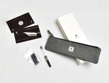 A Piper Trading Co. Franklin-Christoph Model 46 Fountain Pen in Venetian Red, featuring a Franklin-Christoph nib, an ink cartridge, warranty cards, a gray zippered pen pouch, and a white box are arranged on a white surface.