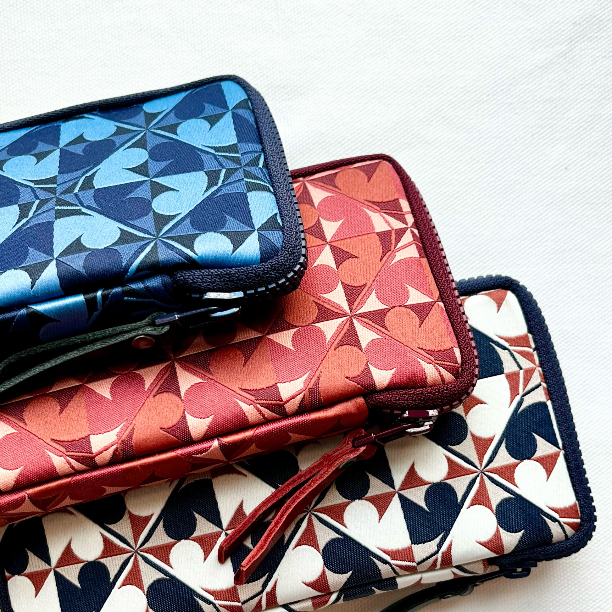 Three patterned pouches stacked on a white background