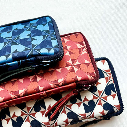 Three patterned pouches stacked on a white background